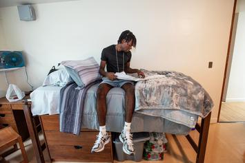 On the first day of orientation, a student pauses on his bed to review Messina materials.